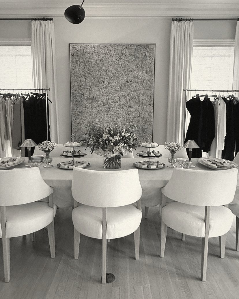 A dining room set for a trunk show, with rails of the collection along the walls